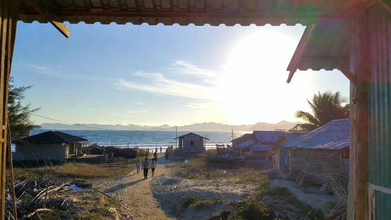 quiet coastal morning Vietnam, local people walking to the sea, soft sunlight, non-touristy village