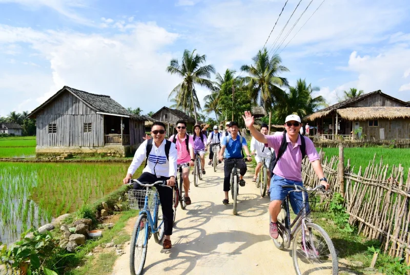 international tourists cycling through Mekong Delta village
